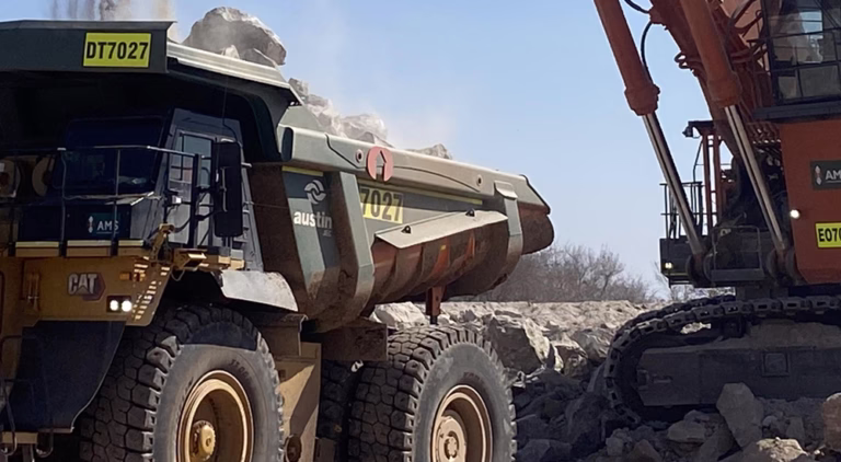 Haul truck being loaded by an excavator at a mining site, showcasing Loadrite fleet insights for real-time payload monitoring and fleet performance.